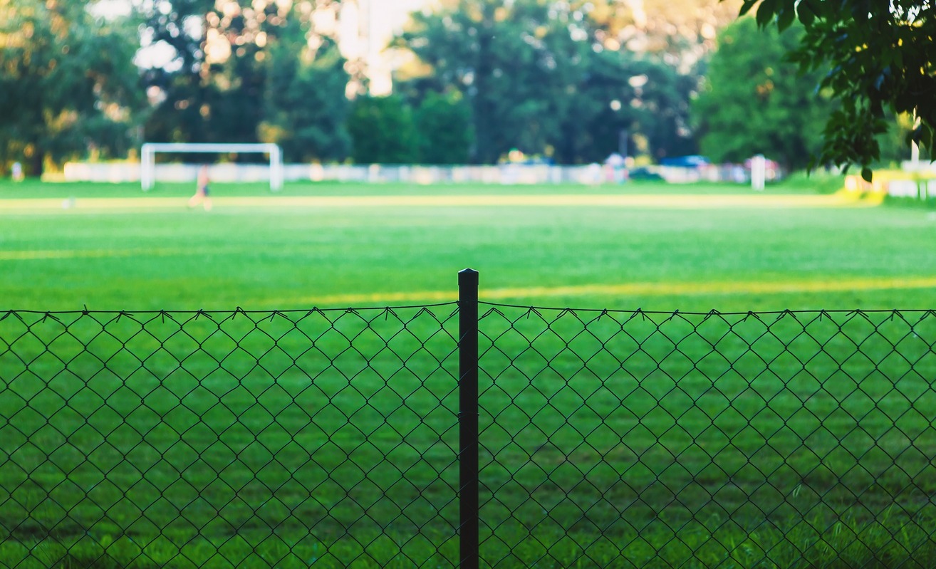 campod e futbol en paeque desenfocado tras la valla